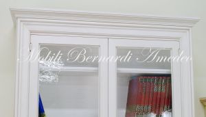 Libreria in legno massello con finitura colore bianco anticato e ante con vetro